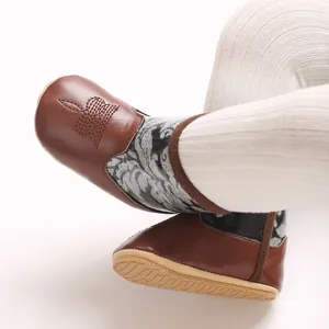 Close-up of baby winter boots with soft anti-slip soles and glitter pattern detail