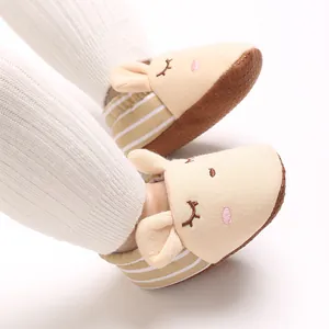 Dettaglio di babbucce beige per neonati con orecchie di animali e suole morbide antiscivolo