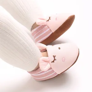 Primo piano di graziose scarpine rosa a forma di coniglio per neonati con suola antiscivolo