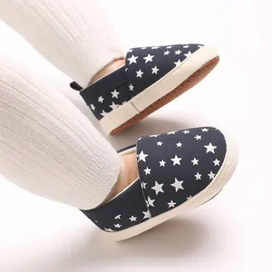 Vista dettagliata delle scarpe primi passi blu navy per neonati con stelle e suola morbida.