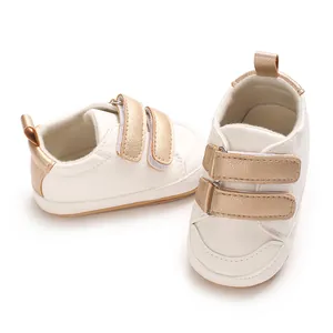 Weiße Baby-Lauflernschuhe aus PU-Leder mit goldfarbenen Klettverschlüssen und weicher Sohle.