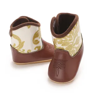 Close-up detail of stylish baby winter boots in brown leather with gold glitter pattern