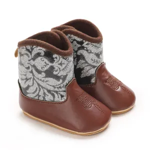 Close-up of stylish brown and silver baby winter boots with soft non-slip soles