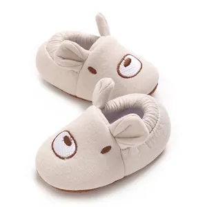 Vista dettagliata di scarpe beige morbide per neonati con design carino di orecchie 3D.