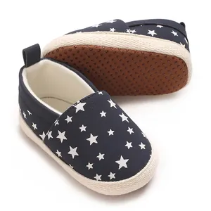 Scarpe da neonato blu scuro con suola morbida e motivo a stelle bianche su fondo bianco