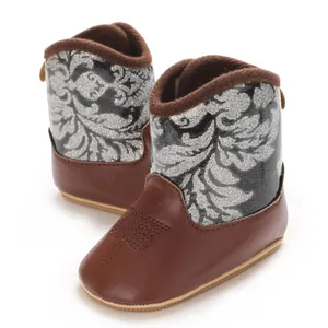 Detailed view of baby winter boots with silver glitter floral pattern and embroidered leaf