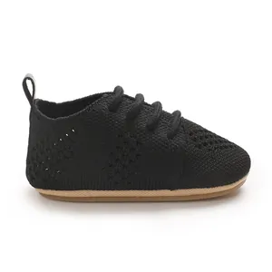 Close-up of black breathable knitted baby walking shoe with brown anti-slip sole