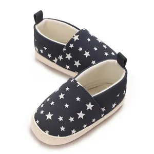 Dettaglio ravvicinato di scarpe da neonato blu scuro con motivo a stelle bianche e suola morbida.