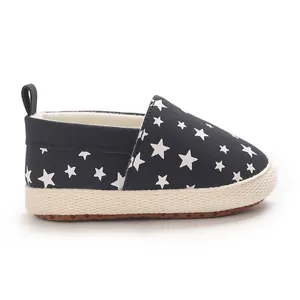 Dettaglio vista laterale di scarpe primi passi per neonati con stelle su tela blu scuro.