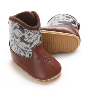 Close-up detail of brown infant winter boots featuring glittery silver shaft and anti-slip sole