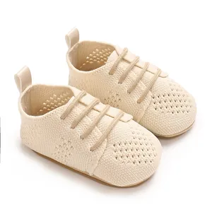 Close-up detail of breathable mesh knit baby walking shoes in a soft cream color