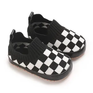 Primer plano de zapatos de punto para bebé a cuadros blancos y negros con suela blanda