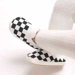 Primer plano de zapatos de punto a cuadros para bebé con unas cómodas mallas blancas