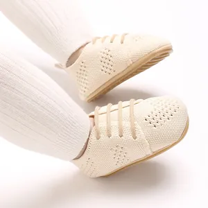 Detail view of breathable cream knit mesh baby walking shoes worn by an infant