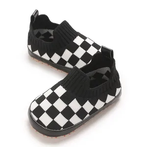 Primer plano de zapatos para bebé con patrón de cuadros tejidos blancos y negros