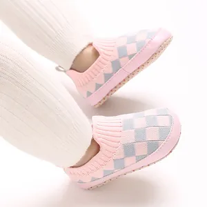 Primer plano de zapatos de punto a cuadros para bebé, transpirables en rosa y gris