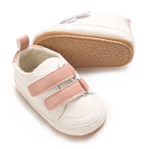 Bequeme weiße Baby-Lernlaufschuhe mit rosa Klettverschluss und weicher Gummisohle.