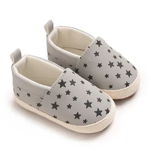 Dettaglio scarpe primi passi grigie per neonati con stelle nere e suola morbida