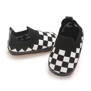 Detalle de la textura de los zapatos de punto para bebé con cuadros blancos y negros.