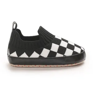 Detalle de zapato de punto para bebé con patrón de cuadros blancos y negros
