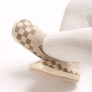 Primer plano de zapatos de punto para bebé con diseño de cuadros y suela antideslizante