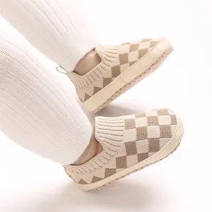Detalle de zapatos de punto para bebé transpirables con patrón de tablero de ajedrez