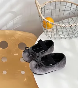 Grey velvet girls' Mary Jane shoes with bow detail on white table