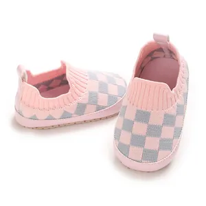 Detalle de zapatos de punto suave para bebé con diseño de cuadros rosas y grises
