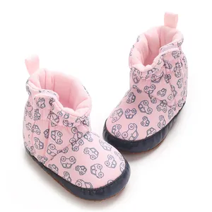 Close-up of soft pink baby boots featuring cute car patterns and high-quality cotton texture.