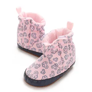 Nahaufnahme der rosa Babystiefel mit niedlichem Auto-Muster und weicher Stoffsohle für Babys