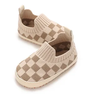 Primer plano de zapatos de punto para bebé a cuadros con suela blanda y transpirables