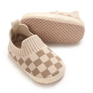 Detalle de los zapatos de bebé de punto a cuadros con suela suave antideslizante