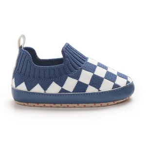 Vista lateral de zapato de punto para bebé con diseño de cuadros azul y blanco suave