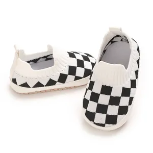 Primer plano de zapatos de punto para bebé con diseño de tablero de ajedrez en blanco y negro