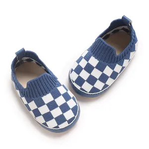 Primer plano del tejido de punto de cuadros azules transpirable de estos suaves zapatos de bebé.