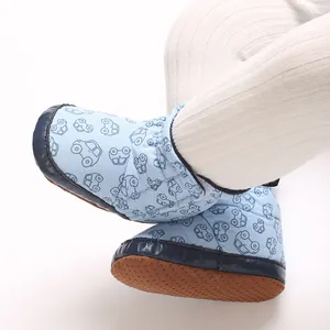 Detail der Babyschuhe mit blauem Automuster und weicher, rutschfester Sohle.