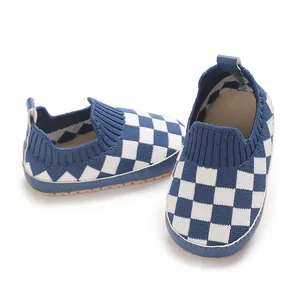 Detalle de zapatos de bebé tejidos a cuadros azul y blanco con textura transpirable