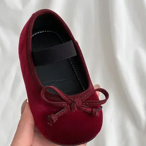 Classic red velvet girl's princess shoes with bow detail and elastic strap for toddlers