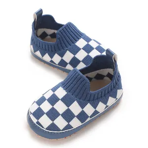 Primer plano de zapatos de punto para bebé con cuadros azules y blancos y suelas blandas.