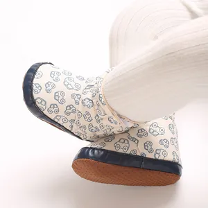 Nahaufnahme von weichen Baby-Schneeschuhen mit süßen Cartoon-Auto-Printmustern