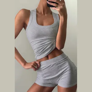 Dettaglio di un top grigio a coste e pantaloncini a vita alta coordinati su una modella