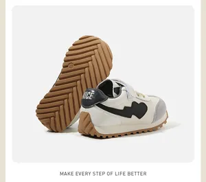 Close-up detail of white children's sneakers with heart pattern and durable brown rubber sole