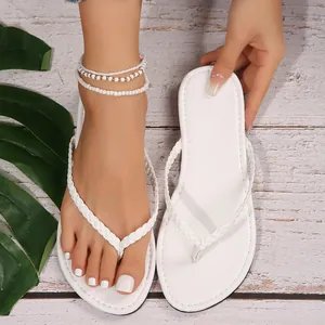 Dettaglio di infradito bianche da donna con eleganti cinturini intrecciati per l'estate.