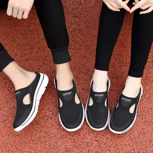 Close-up detail of breathable black mesh slip-on clogs worn by two people on track