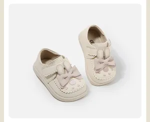 Adorable beige baby girl walking shoes featuring cute rabbit ears and pink bow detail