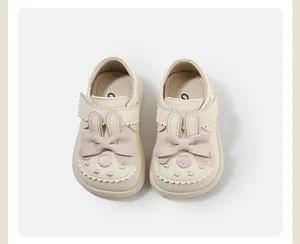 Top view of cute cream baby girl princess shoes with bunny ears and pink bows
