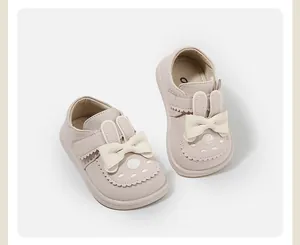 Detailed view of pink toddler girl shoes featuring cute bunny ears and a white bow.