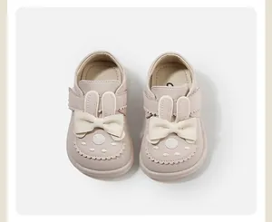 Close-up of cute pink toddler shoes with rabbit ears and bows
