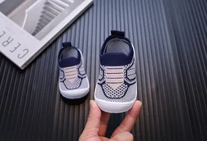 Primo piano di scarpa primi passi per neonati in maglia traspirante con suola morbida.