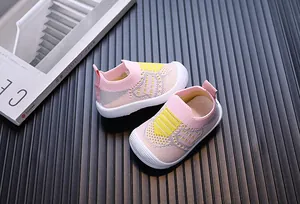Primo piano di scarpe primi passi in rete traspirante rosa e giallo per neonati